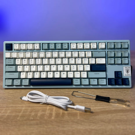 Mechanical keyboard with a cable on a wooden surface and blue gradient background
